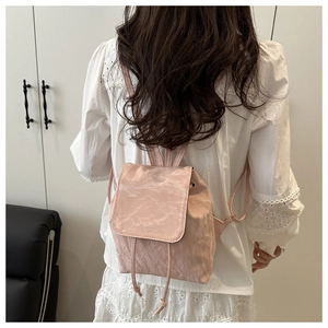 Détail du mini sac à dos rose en similicuir plissé avec cordon et rabat de fermeture