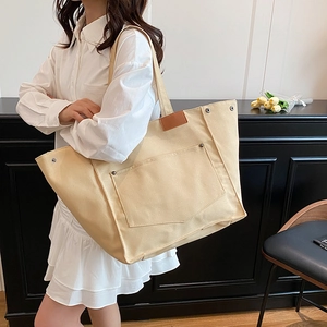 Minimalist beige canvas tote bag for women with wide shoulder straps and outer pocket