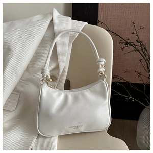 Detail of cream PU leather hobo bag with unique knot shoulder strap and logo text
