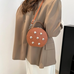 Fashionable round brown leather crossbody bag with silver studs and adjustable strap