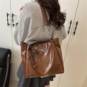 Brown faux leather tote bag with silver bow detail and chain strap for women