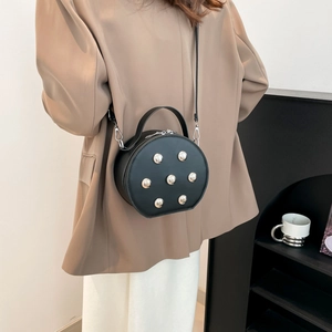 Minimalist black round crossbody bag with silver studs and top handle for women