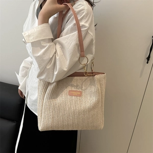 Woven straw tote bag with pink leather straps for seaside vacations and spring outings