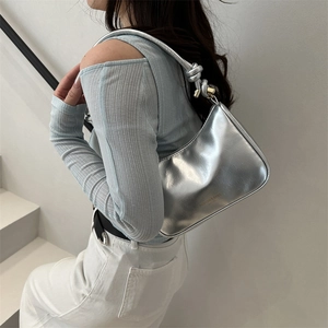 Chic silver metallic crescent underarm bag with knot detail and gold hardware accents