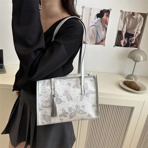 Chic silver tote bag with butterfly star patterns and grey tassel for women's shoulder wear