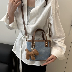 Blue denim and brown leather bucket bag with puppy charm and adjustable strap