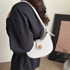 Minimalist white crescent shoulder bag with gold ring closure shown on model