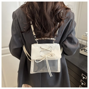 Dettaglio di uno zaino in PU bianco con fiocchi decorativi e inserto in rete grigio scuro
