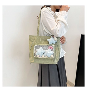Detail view of avocado green ita bag with clear window and plush star charms