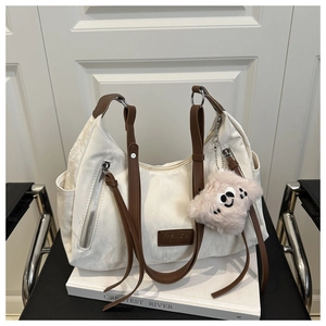 Detail of cream large tote bag featuring brown leather straps and fashion logo tag