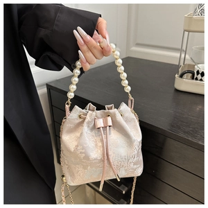 Detail of floral jacquard bucket bag with pearl handle and drawstring closure