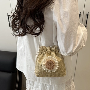 Minimalist straw bucket bag with sunflower detail and white drawstring shoulder strap