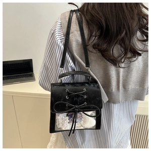 Dettaglio della borsa ita in velluto nero con lacci in nastro e finestra in PVC