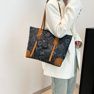 Sac cabas rétro à imprimé lettres avec finitions en cuir marron porté par un mannequin
