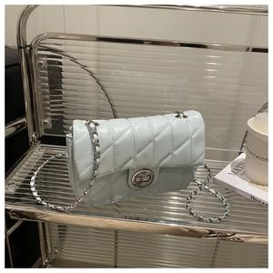 Détail d'un sac à bandoulière matelassé bleu clair avec chaîne et fermoir argenté