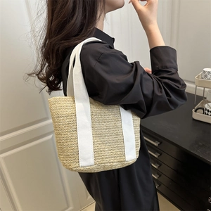 Minimalist woven straw tote bag with white canvas handles for spring casual look