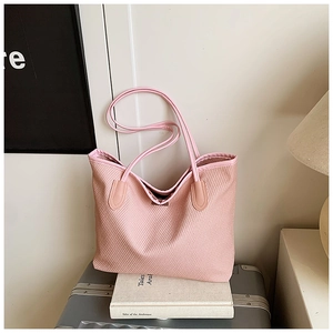 Detail of pink woven tote bag with waffle texture and premium leather shoulder strap