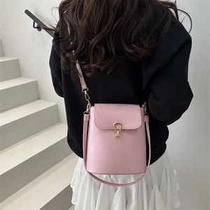 Sac seau minimaliste en cuir rose clair avec fermoir doré en forme de goutte d'eau