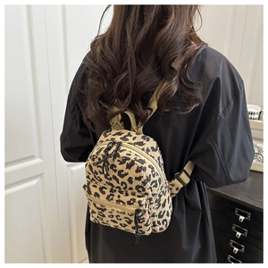 Detailed view of mini leopard print corduroy backpack with adjustable straps on model