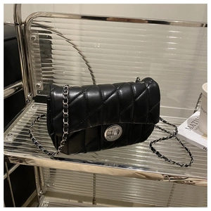 Détails du sac bandoulière noir matelassé avec chaîne argentée et fermoir pivotant