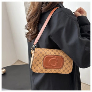 Close-up of vintage monogram shoulder bag with gold hardware and embossed G logo detail