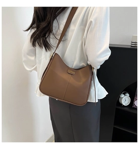 Vue détaillée arrière d'un sac seau en cuir marron avec plaque fashion dorée et bandoulière
