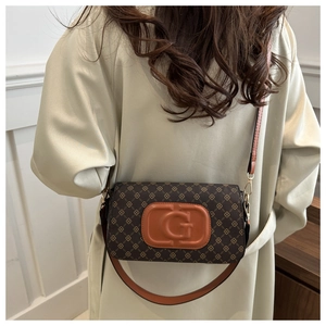 Detail of printed brown small square bag with orange G-letter logo and leather strap