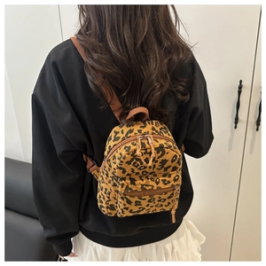 Detailed view of corduroy leopard print mini backpack worn by a model in casual style