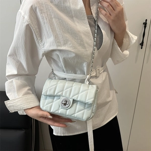 Sac bandoulière matelassé bleu clair avec chaîne argentée porté par un mannequin