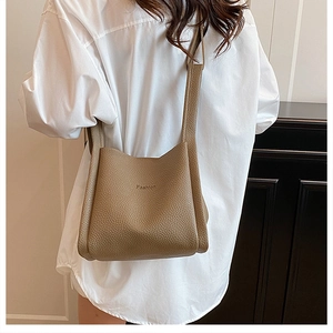 Close-up of brown litchi leather bucket bag showing stitching and Fashion engraving