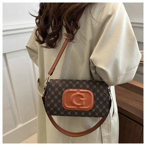 Detail of vintage brown checkered crossbody bag worn with a beige trench coat