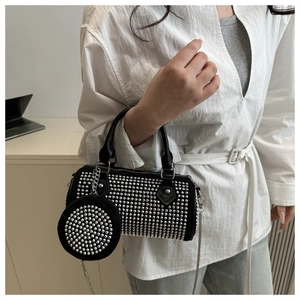 Détail du sac cylindrique noir avec rivets argentés et mini porte-monnaie assorti