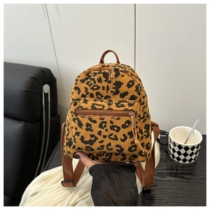 Close-up of vintage leopard print corduroy mini backpack with brown straps and zippers