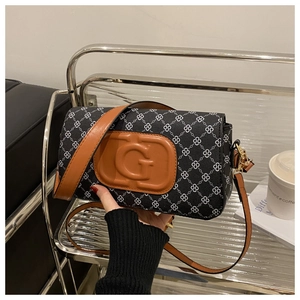 Detail of clover print shoulder bag with prominent embossed G logo and gold hardware