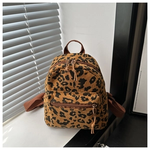 Macro detail of leopard print corduroy mini backpack showing texture and dual zippers