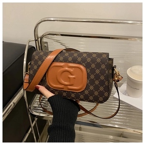 Close-up of the vintage brown monogram pattern and metallic G buckle on the bag
