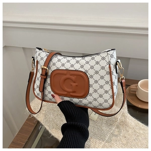 Detail of floral patterned shoulder bag with brown leather trim and G-embossed logo plaque