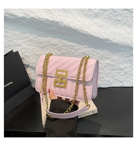 Détail du sac à main matelassé rose avec fermoir géométrique doré et bandoulière chaîne