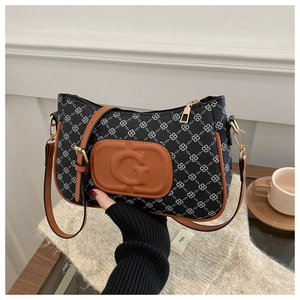 Detail of vintage flap bag with classic pattern, brown leather trim and G-embossed patch
