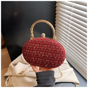 Dettaglio borsa da sera in tweed bordeaux con manico dorato e chiusura in strass