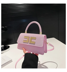 Detailed shot of a pink leather handbag featuring a sparkling sequined flap and gold logo