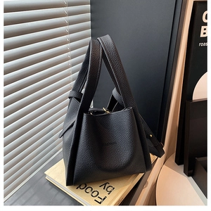 Close-up of black litchi pattern leather bucket bag with Fashion embossed logo and strap