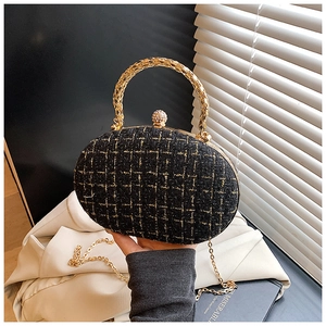 Dettaglio della borsa da sera in tweed con manico ad anello dorato e chiusura a sfera