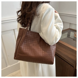 Λεπτομέρεια καφέ τσάντας tote με ανάγλυφο houndstooth και σχέδιο πλεκτής λαβής