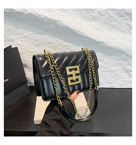 Détail du sac à bandoulière en cuir matelassé noir avec boucle dorée et bandoulière chaîne