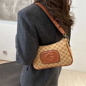 Retro beige monogram shoulder bag with brown leather trim worn with a grey blazer