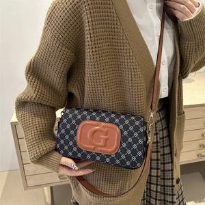 Women's checkerboard crossbody bag with brown leather accents and gold logo detail