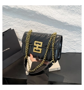 Détail du sac à bandoulière matelassé noir avec chaîne dorée et fermoir en métal