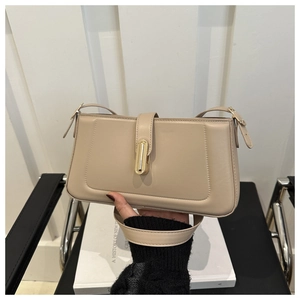 Detail of beige leather bag with gold metal buckle and adjustable strap clasp