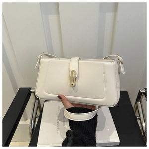 Detail of a creamy white leather shoulder bag featuring a sleek gold metal buckle